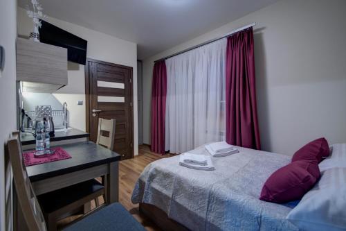 考斯赛力克Willa Świderka的一间卧室配有一张床、一张书桌和一个窗户。