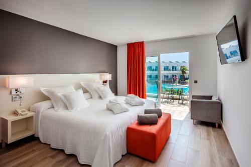 科拉雷侯科拉莱霍巴塞罗沙滩酒店的卧室配有一张白色大床和红色凳子