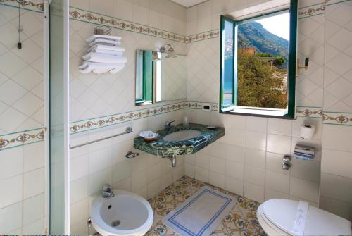 维克艾库塞美嘉马雷酒店的一间带水槽和卫生间的浴室以及窗户。