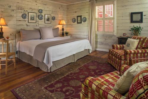 ClarkesvilleGlen-Ella Springs Inn的一间卧室配有一张床、一张沙发和一把椅子