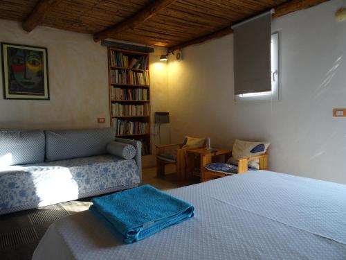BerchiddedduLa Scala Guesthouse的一间卧室配有一张床、一张沙发和一台电视。