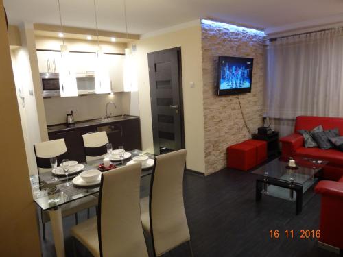 克雷尼察Apartament Kryształowy的客厅配有桌子和红色沙发
