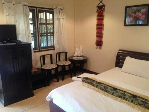 湄安蒙克奥旅馆的一间卧室设有一张床、一台电视和一个窗口。