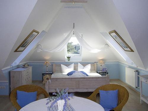 蒂门多弗施特兰德Haus Anholt的一间卧室配有一张带两张桌子和一扇窗户的床。