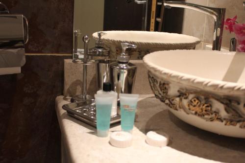 利雅德شقق درر رامه للشقق المخدومة 4的浴室设有水槽和2瓶水的台面