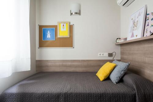 瓦伦西亚科莱焦梅尔公寓式酒店的一间卧室配有一张黄色枕头的床