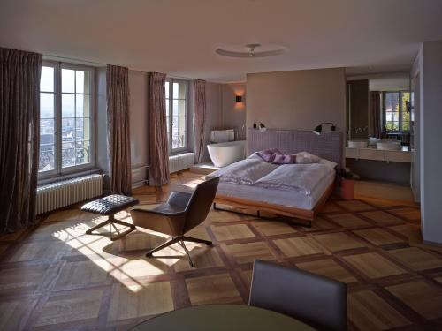 图恩施罗斯堡精品酒店 的一间卧室配有一张床和椅子,还设有一间浴室