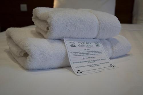 伦敦切尔西宾客别墅酒店的床上的一堆白色毛巾