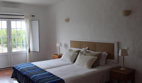圣地亚哥-杜卡森Casas de Miróbriga的一间卧室设有一张大床和一个窗户。