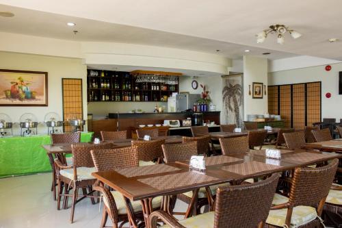 麦克坦Palmbeach Resort & Spa Mactan, Cebu的一间在房间内配有桌椅的餐厅