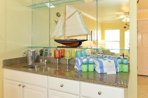 克利尔沃特赤脚海滩度假酒店的厨房设有水槽,墙上设有帆船