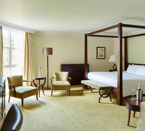 诺里奇Sprowston Manor Hotel, Golf & Country Club的配有床、椅子和桌子的酒店客房