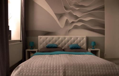 波普拉德Apartment Centrum number 8的卧室配有一张挂有山壁画的床。