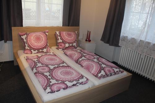 厄林根Bismarck Hostel Öhringen的一间卧室配有一张带粉色和白色床单及枕头的床。