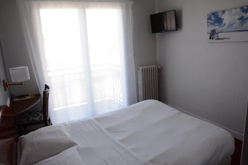 圣布里文莱丝皮恩Logis Le Petit Trianon的卧室配有白色的床和窗户。