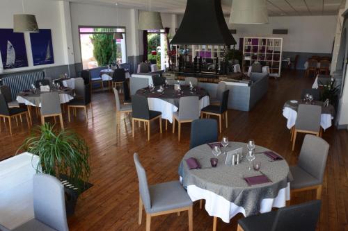 圣布里文莱丝皮恩Logis Le Petit Trianon的一间带桌椅的用餐室和一间餐厅