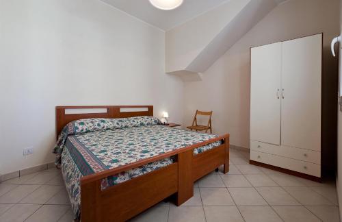 莱乌卡Casa del Sole by BarbarHouse的一间卧室配有一张床、一个橱柜和一把椅子