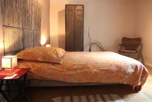 Saint-UrbainMoulin De Beuzidou的一间卧室配有一张床、一把椅子和一张桌子