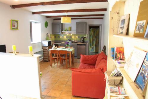 Saint-UrbainMoulin De Beuzidou的厨房配有红色的沙发和桌子