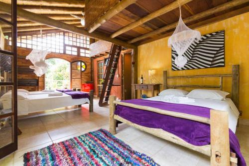 帕拉蒂-米林Paraty Paradiso的一间卧室设有两张床、梯子和地毯。