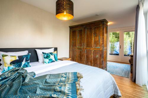 阿姆斯特丹里耶特兰住宿加早餐旅馆的一间卧室配有一张大床和木柜