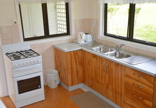 拉罗汤加Flame Cottage的小厨房配有炉灶和水槽