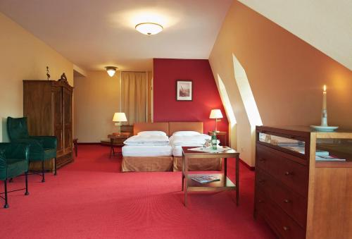 卑尔根考夫曼斯霍夫罗曼蒂克酒店的酒店客房,配有床铺和红地毯