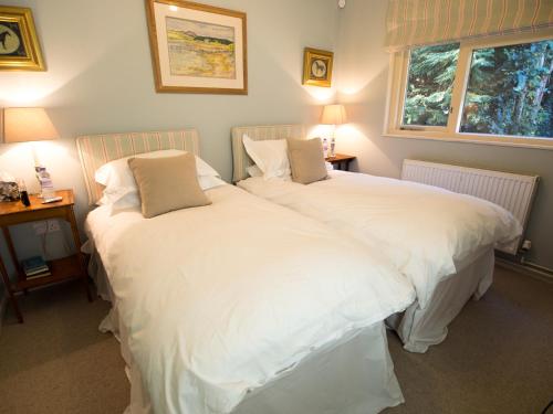 MaidfordYew Tree Cottage的卧室内两张并排的床
