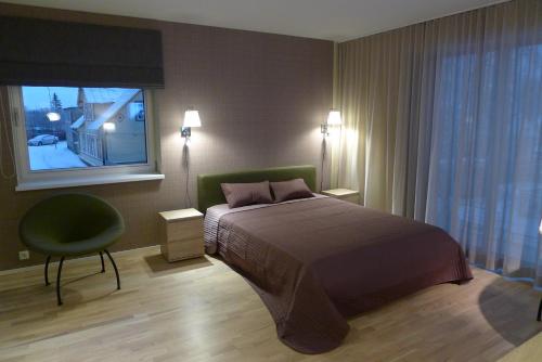 哈普萨卢Liiva Seaside Apartment的卧室配有床、椅子和窗户。