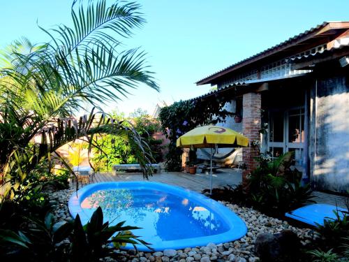 弗洛里亚诺波利斯Pousada Villa da Nascente的一个带遮阳伞的庭院内的游泳池