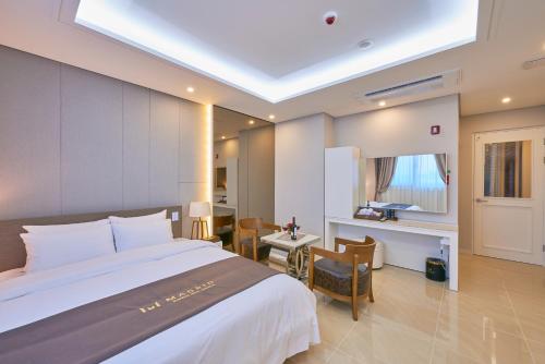 光州光州马德里酒店的酒店客房设有一张大床和一张书桌。