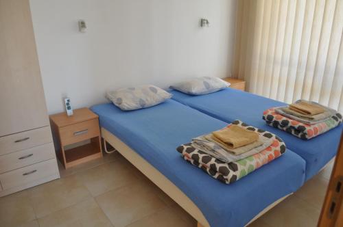 比亚拉Villa Sun Village Byala的一间卧室配有两张单人床和蓝色床单