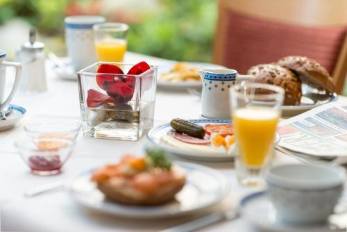 盖尔森基兴祖姆施万安姆比恩特酒店的餐桌,带食物盘和橙汁杯