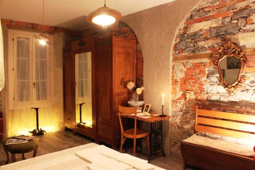 科莫勒达米德拉科尔塞拉住宿加早餐旅馆的卧室设有砖墙、一张床和一张桌子