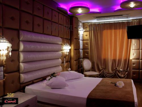 比雷埃夫斯卡罗尔酒店的一间卧室配有一张床和紫色照明