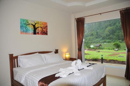 攀牙泰国异域垂钓旅馆的一间卧室配有一张带白色毛巾的床