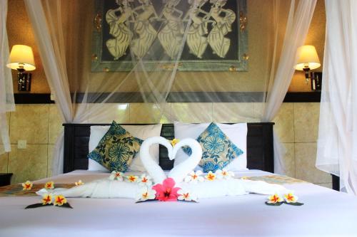 佩母德兰草堂新都旅馆的一张有两只天鹅的睡床,看起来像心