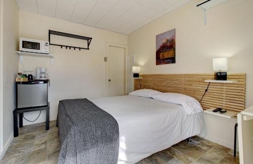 圣弗拉维圣帕特里克公寓汽车旅馆的一间小卧室,配有一张床和一台微波炉