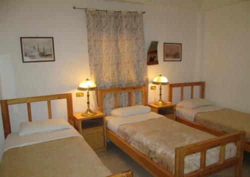 卢克索卢克索卡林酒店的一间卧室设有三张床和两张台灯。