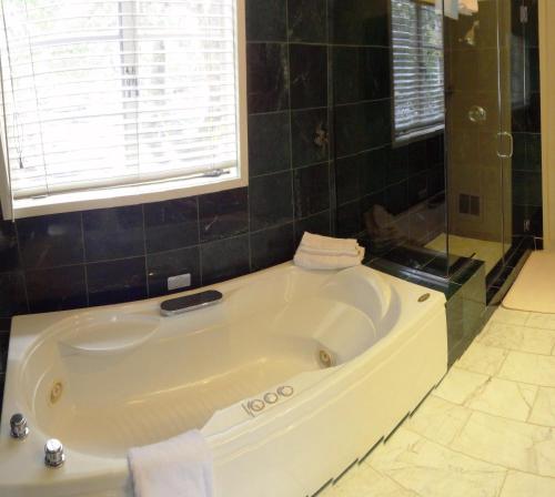 卡梅尔绿林狩猎旅馆的带窗户的浴室内的白色大浴缸