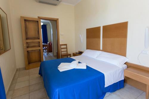 圣伊西多罗塞娃吉奥港度假酒店的酒店客房,配有一张带蓝色毯子的床