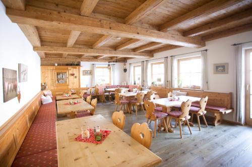 雷特温克尔贝姆内豪萨酒店的餐厅设有木桌、椅子和窗户。