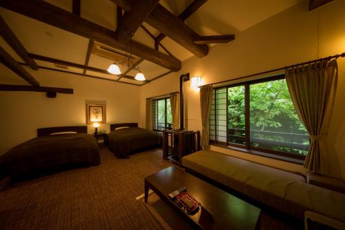 南小国町富士屋旅馆的一间卧室设有两张床和大窗户