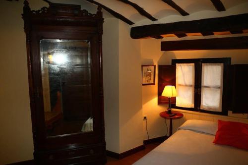 阿尔内迪略Casa Rural Las Pedrolas的一间卧室配有一张床和一个大型木制橱柜