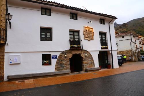 阿尔内迪略Casa Rural Las Pedrolas的街道上带有石头门道的白色建筑