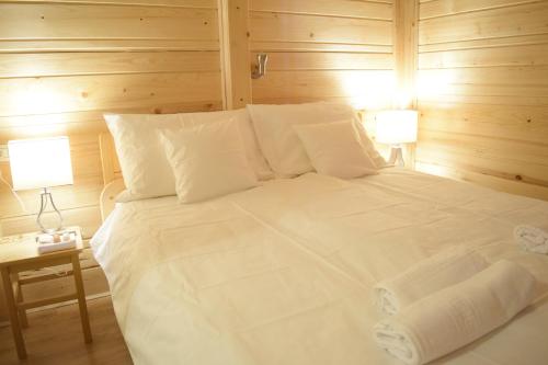 GoreljekChalet Pokljuka的卧室配有带两盏灯的白色床