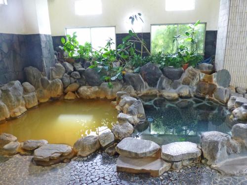 沼津苏伊森卡库酒店的岩石间中间的一个池塘