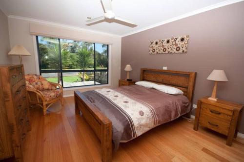 莱克斯恩特伦斯坎布罗度假屋的卧室配有床、椅子和窗户。