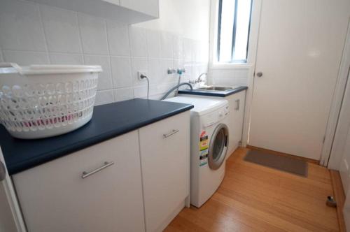 莱克斯恩特伦斯坎布罗度假屋的厨房配有洗衣机和水槽
