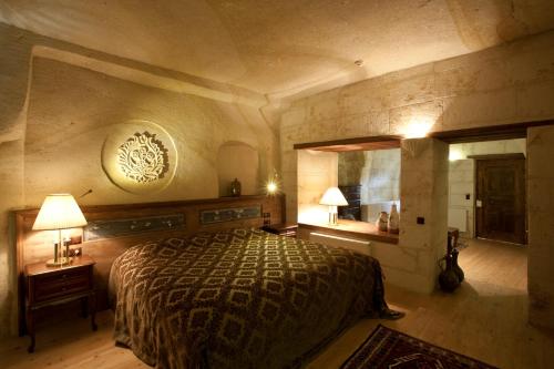 于尔居普卡帕多西亚弗雷斯科窟套房酒店的一间卧室配有一张大床和镜子